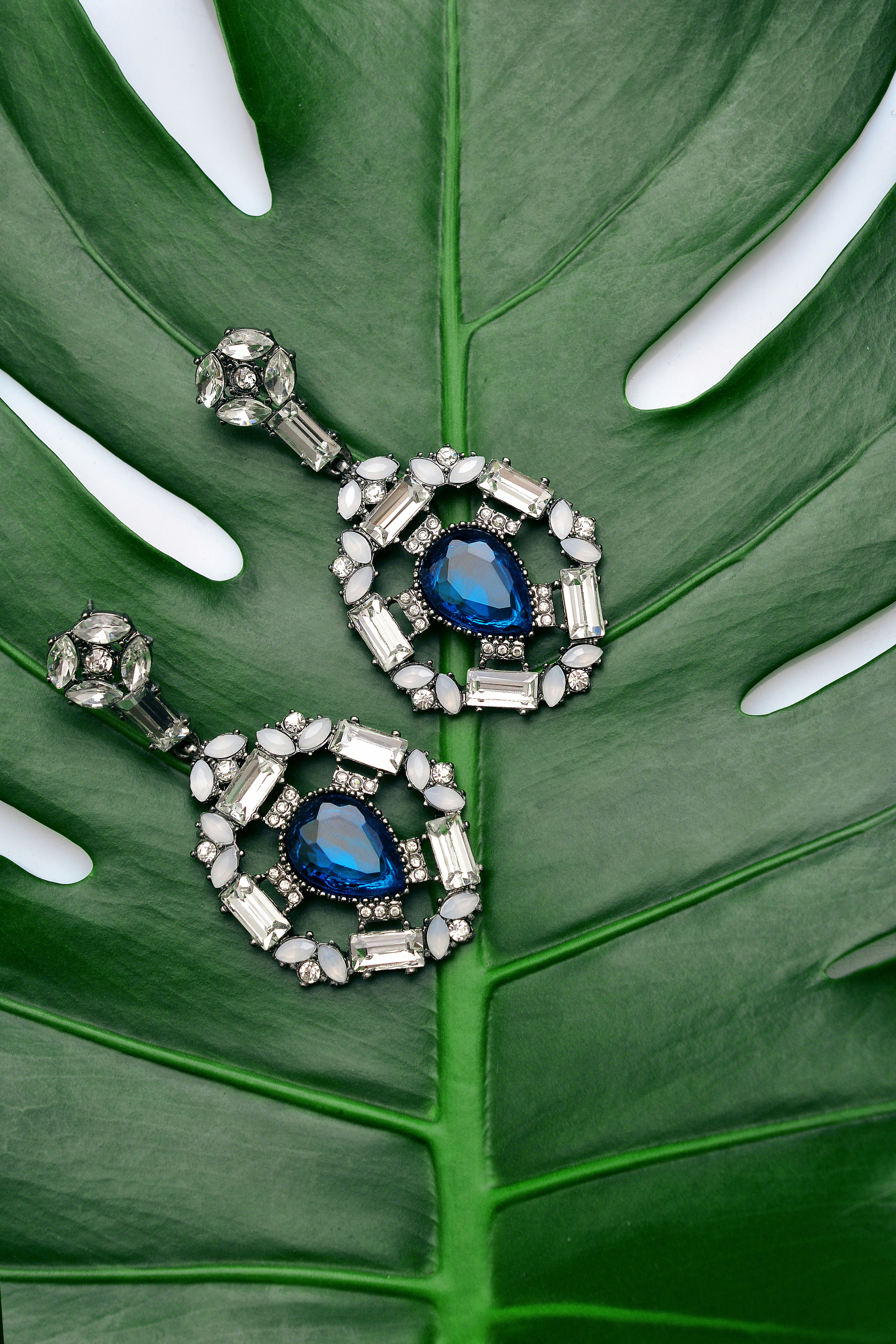 Boucles d'oreilles saphir bleu sur feuille tropicale