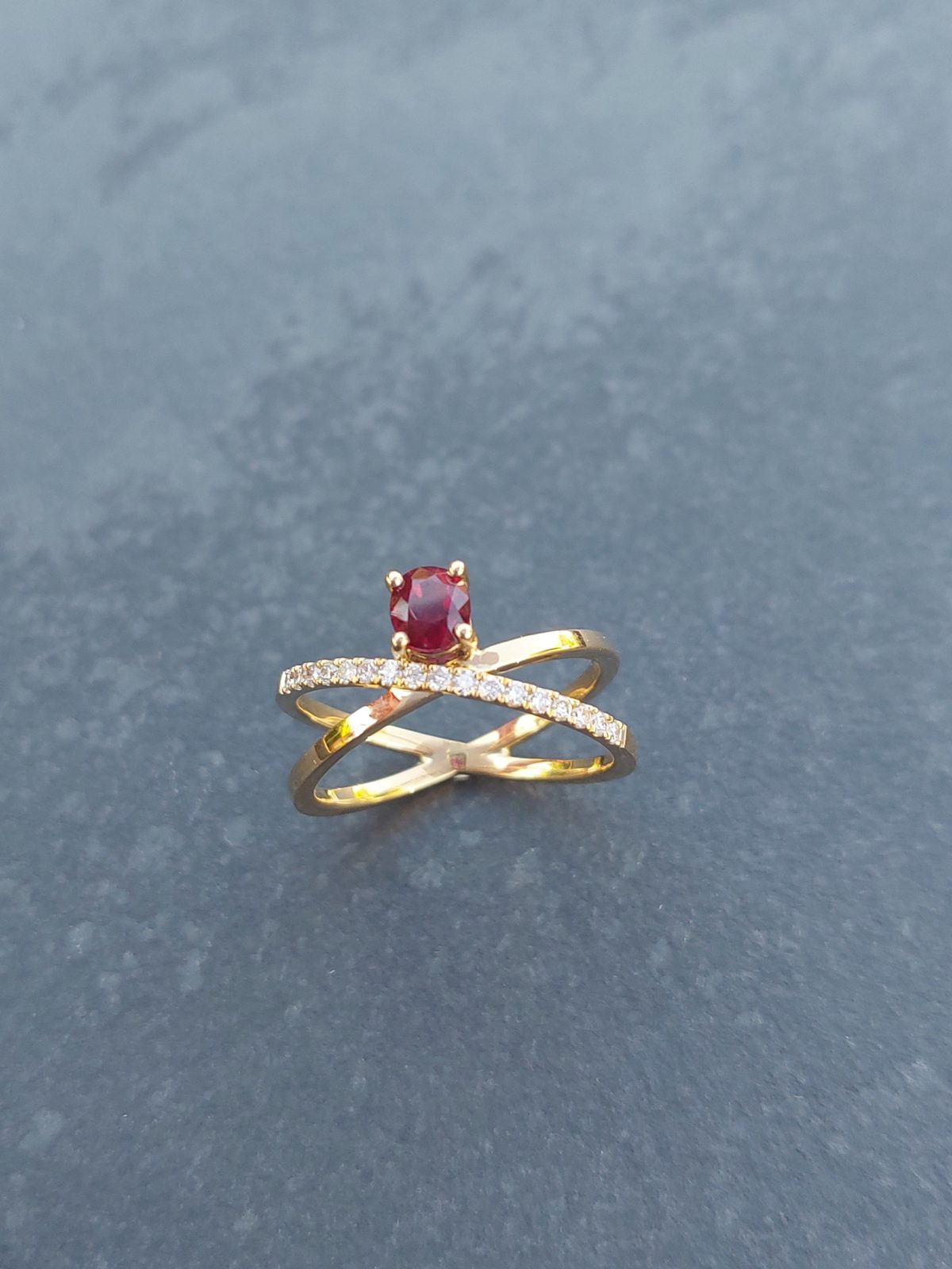 Bague croisée en or sertie d'une pierre rouge et d'une ligne de diamants
