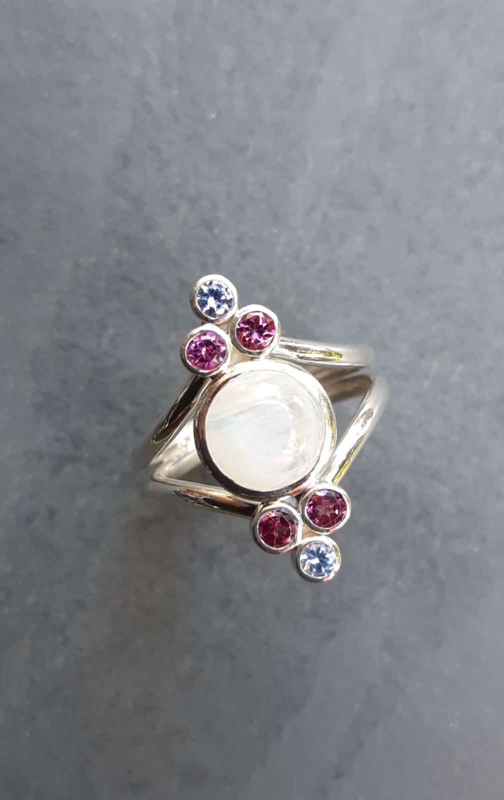Bague en argent sertie d'une pierre de lune, de tourmalines roses et de pierres bleues