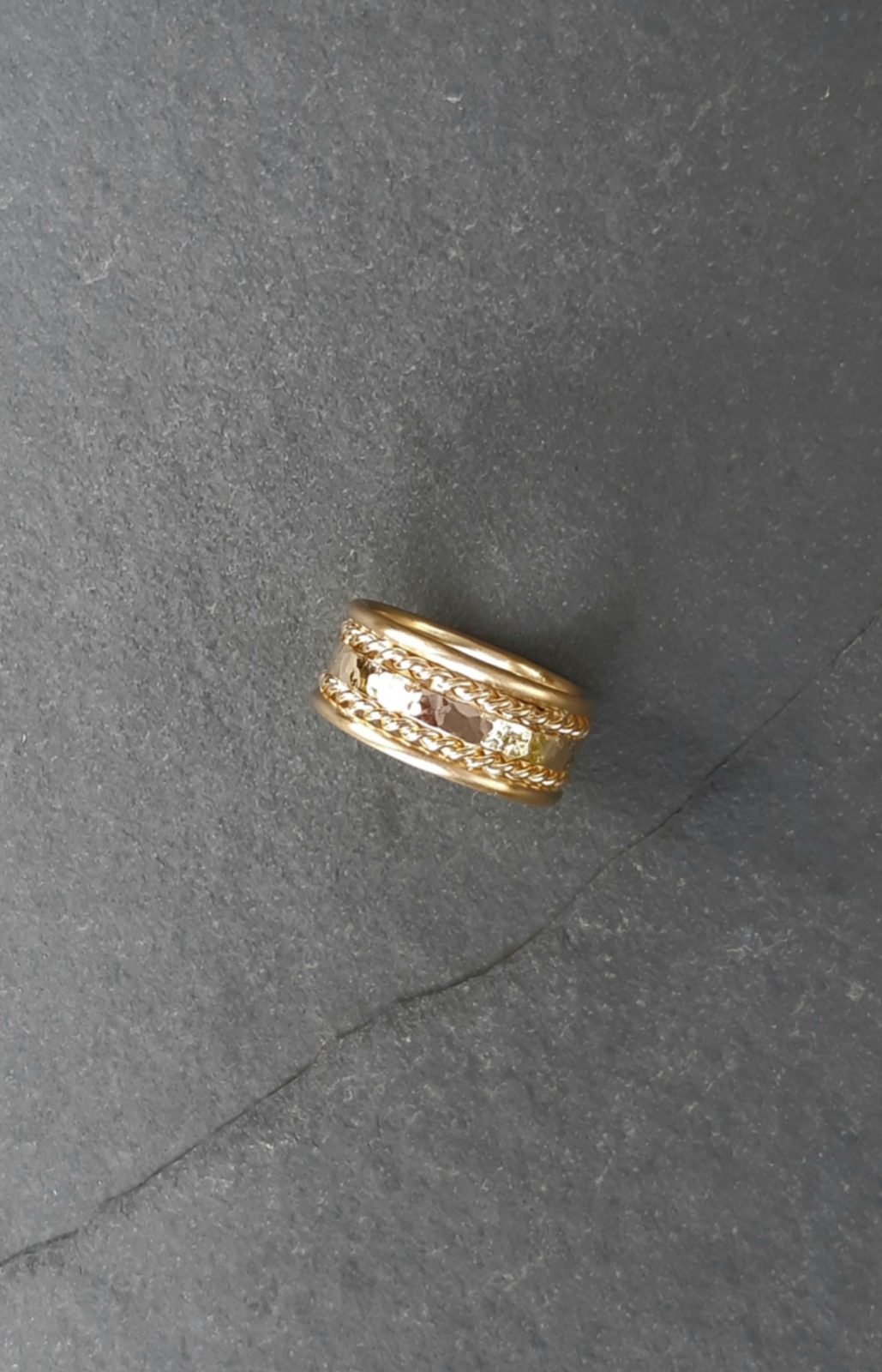 Bague large en or bordée de torsades et sertie d'un diamant